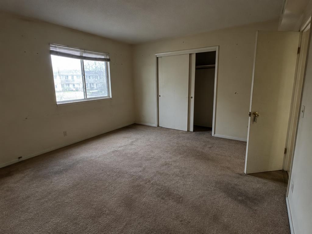 Bedroom before painting, with wall marks and nail holes
